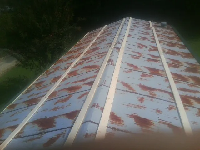 Rusted metal roof panels with new wood purlins before replacement — Storm Damage Roof Repair in Edinboro by Roofing Brothers