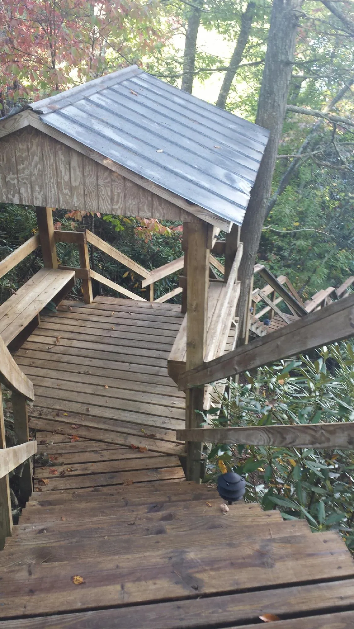 Metal roofed shelter over wooden steps on a wooded walkway — Skylight Repair & Installation work by our crew in Edinboro