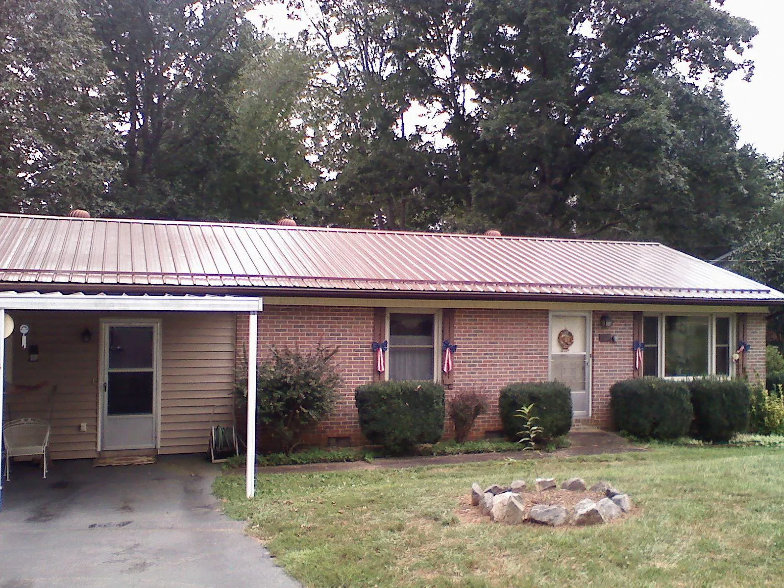 Bronze metal roof and carport on a brick ranch home — Roof Repair work by our crew in Edinboro